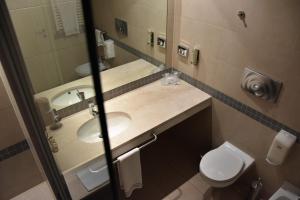 a bathroom with two sinks and a toilet and a mirror at Hotel Motel Prestige in Grugliasco