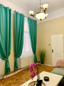 sala de estar con cortinas verdes y mesa en Art Nouveau Apartment Ultracentral en Oradea