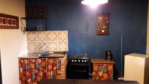 a small kitchen with a stove and a sink at Poente Guest House in Conceição da Ibitipoca
