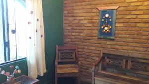 a room with a brick wall with a clock on it at Poente Guest House in Conceição da Ibitipoca