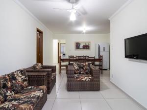 uma sala de estar com sofás e uma televisão de ecrã plano em Apartamento com ar condicionado e Wi-fi, frente mar - 02 dormitórios - Edifício Luz do Sol em Ubatuba