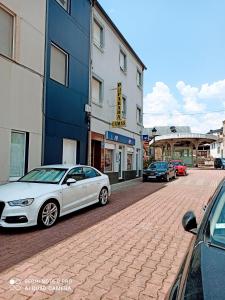 een witte auto geparkeerd in een straat naast een gebouw bij PENSION LA PARADA in Fabero