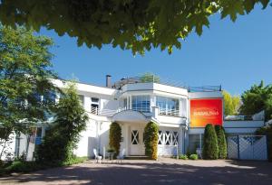 un edificio blanco con un letrero rojo. en ASLAN Kurpark Villa Olsberg en Olsberg