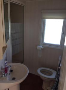 a bathroom with a sink and a toilet and a window at L&g FAMILY HOLIDAYS 8 BERTH SEALANDS FAMILYS ONLY AND THE LEAD PERSON MUST BE OVER 30 in Ingoldmells +18 photos
