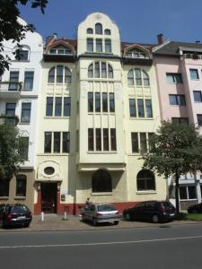 a large building with cars parked in front of it at Avalon Bed & Breakfast Themen/- Nichtraucherhotel in Hannover