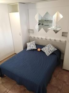 a bedroom with a blue bed with two pillows at House Lilu - luminoso monolocale in Arona