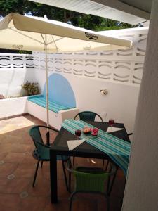 a patio with a table and chairs and an umbrella at House Lilu - luminoso monolocale in Arona