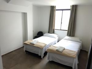 2 camas en una habitación con ventana en Hotel Tayromar, en Santa Marta