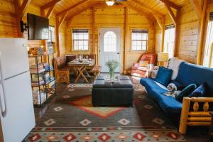a living room with a blue couch and a table at Paradise Valley Cabin by Chico and Yellowstone Park! in Livingston