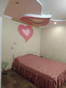 a bedroom with a bed with a heart on the wall at 2 кімн. кв. "Романтік" in Cherkasy