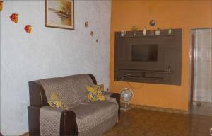a living room with a couch and a flat screen tv at Casa do Carlos, praia da Enseada Ubatuba-SP in Ubatuba