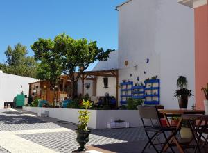 een terras met een tafel en stoelen en een gebouw bij Luxurious Pink House and Parking in Porto