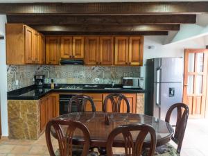 una cucina con armadi in legno e tavolo con sedie di Apartamento Madeiro a Villa de Leyva