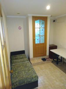 een kleine kamer met een bed en een deur bij частный дом, отдельный вход и двор in Tsjerkasi