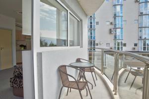 a balcony with two chairs and a table at Апартамент Евксиновград, една спалня - безплатен паркинг, Варна in Varna City