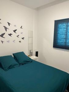 a bedroom with a bed with birds on the wall at Apartamentos Candelarita in Gran Tarajal