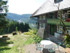 ein Haus mit einem Tisch und Stühlen auf einer Terrasse in der Unterkunft Feißesberghof in Triberg