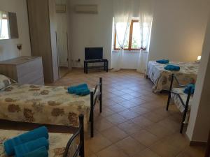 a living room with three beds and a television at Residence Argentiera in Miniera dellʼArgentiera