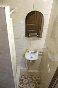 W łazience znajduje się umywalka i lustro. w obiekcie Privatnyy Khostel w mieście Chortkiv