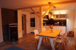 uma cozinha e sala de jantar com mesa e cadeiras em Gute Laune Hof Klingenthal em Klingenthal
