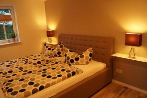 um quarto com uma cama com almofadas em Gute Laune Hof Klingenthal em Klingenthal