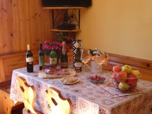 Baita Figliezzi في كاستيلو تيسينو: طاولة عليها زجاجات من النبيذ والفواكه