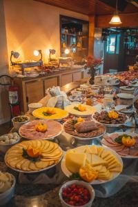 a buffet with many plates of food on a table at Hotel Tirol in Treze Tílias