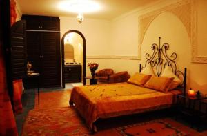 a bedroom with a large bed and a mirror at Riad La Perle de Marrakech in Marrakesh