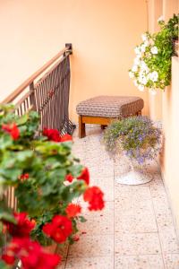 un banco sentado en un balcón con flores rojas en 2- posteľová izba s kúpeľňou EMKA v PENZION TRSTENÁ, en Trstená