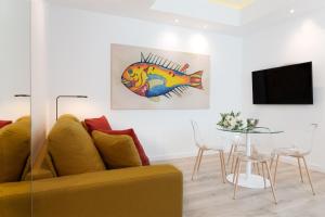 Una sala de estar con un sofá amarillo y una mesa. en Lauser City Suites, en Los Llanos de Aridane