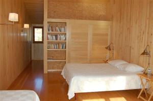 a bedroom with two beds and a book shelf at Maison Rouge in Plan dʼAups