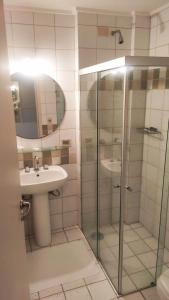 a bathroom with a glass shower and a sink at Hotel Metrópolis in Sao Jose do Rio Preto