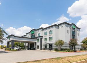 un gran edificio blanco con aparcamiento en Wingate by Wyndham and Williamson Conference Center, en Round Rock