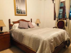 ein Schlafzimmer mit einem Bett und einer Kommode mit zwei Lampen in der Unterkunft El Capricho by Rotamundos in Xicotepec de Juárez
