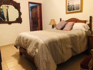 ein Schlafzimmer mit einem Bett mit einem Spiegel und einem Bett mit einem sidx sidx sidx in der Unterkunft El Capricho by Rotamundos in Xicotepec de Juárez