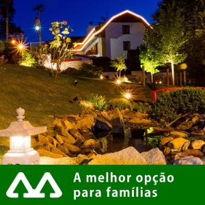 a melior agoria para familia sign in front of a yard at night at Hotel Matsubara in Campos do Jordão