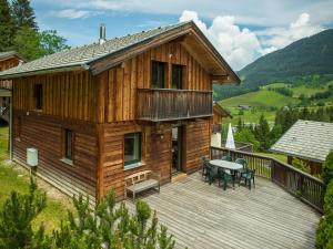 a wooden house with a deck and a table at Spacious Chalet in Annaberg-Lungötz with sauna in Annaberg im Lammertal