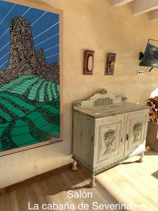 a large painting of a mountain on a wall next to a table at La Cabaña de Severina in Sotres