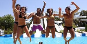 a group of people jumping in a swimming pool at Hotel Ausonia in Follonica