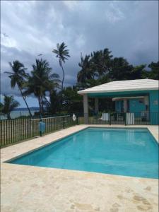 a blue swimming pool in front of a house at Casa Del Mar !!! Ocean front villa in Aguada