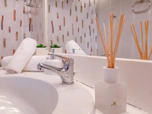 een badkamer met een wastafel en een vaas met bamboe bij Kalliopi's apartment in Athene