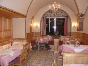 a restaurant with tables and chairs and a chandelier at Gasthof Goldene Traube in Golling an der Salzach