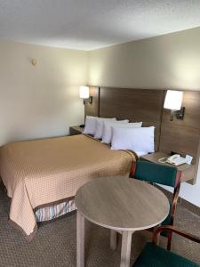 a hotel room with two beds and a table at Riverside Motor Lodge - Pigeon Forge in Pigeon Forge