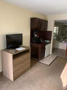 a room with a kitchen with a tv and a desk at Riverside Motor Lodge - Pigeon Forge in Pigeon Forge