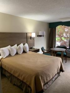 a hotel room with a large bed with white pillows at Riverside Motor Lodge - Pigeon Forge in Pigeon Forge