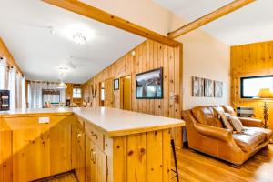 a kitchen with wood paneling and a leather chair at On The River in Estes Park