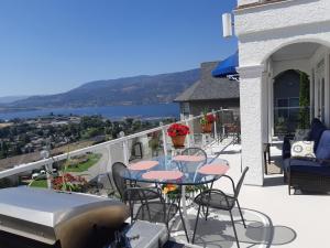a balcony with a table and chairs and a boat at Vacation Lake View House kelowna BNB in Kelowna