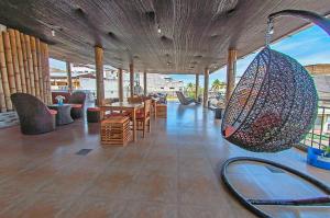 a room with a table and chairs and a swing at Hostal Costa del Pacifico in Puerto Ayora