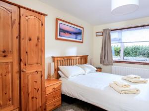 a bedroom with a bed and a dresser and a window at 49 Cumber Close in Malborough