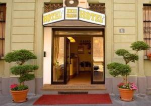 ein Hotelhaus mit zwei Topfpflanzen davor in der Unterkunft Hotel 22 Marzo in Mailand